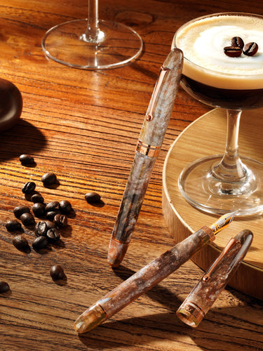 Caffè macchiato with coffee beans and a pipe on a wooden surface